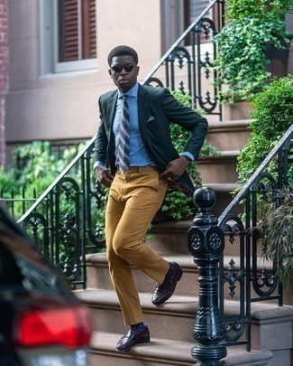 Как носить темно-зеленый пиджак с светло-коричневыми классическими брюками мужчине в деловом стиле: Комбо из темно-зеленого пиджака и светло-коричневых классических брюк — прекрасный пример делового городского стиля. Вместе с этим луком прекрасно выглядят темно-красные кожаные лоферы.