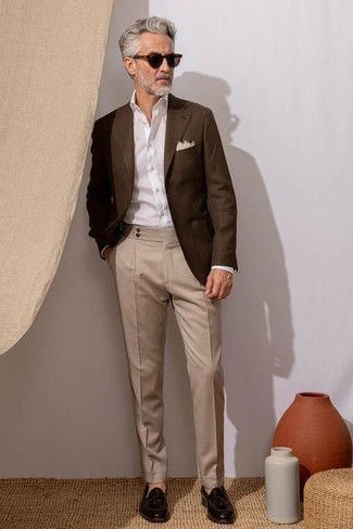 С чем носить коричневый пиджак мужчине в теплую погоду: Сочетание коричневого пиджака и бежевых классических брюк поможет исполнить строгий мужской стиль. В тандеме с этим образом чудесно будут выглядеть темно-коричневые кожаные лоферы с кисточками.