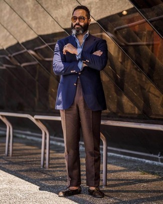 С чем носить темно-коричневые замшевые лоферы мужчине в теплую погоду: Темно-синий пиджак в сочетании с темно-коричневыми классическими брюками позволит реализовать строгий мужской стиль. Пара темно-коричневых замшевых лоферов очень просто вписывается в этот лук.