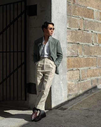 С чем носить темно-зеленый пиджак мужчине: Сочетание темно-зеленого пиджака и бежевых классических брюк позволит реализовать строгий деловой стиль. В сочетании с этим ансамблем стильно будут смотреться темно-коричневые кожаные лоферы.