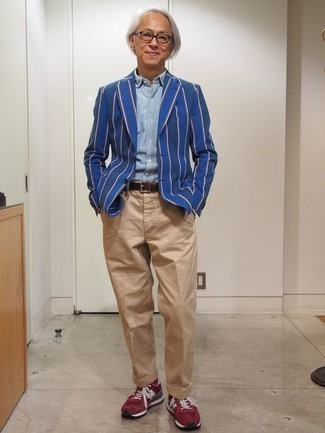 С чем носить кроссовки за 50 лет мужчине: Сочетание синего пиджака в вертикальную полоску и светло-коричневых брюк чинос — отличный пример непринужденного офисного стиля для молодых людей. Кроссовки позволят сделать ансамбль не таким официальным.