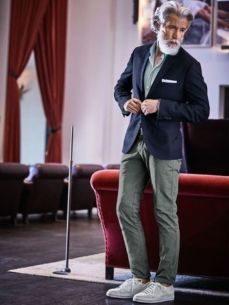 Какие брюки чинос носить с темно-синим пиджаком за 60 лет в теплую погоду в стиле смарт-кэжуал: Если ты из той категории мужчин, которые разбираются в моде, тебе придется по вкусу тандем темно-синего пиджака и брюк чинос. Этот образ стильно дополнят серые низкие кеды из плотной ткани.