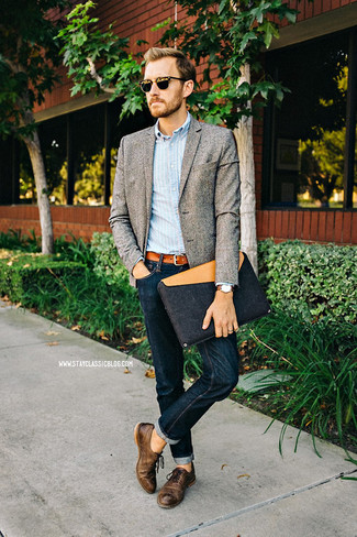 Как носить темно-синие джинсы с коричневыми кожаными оксфордами в 30 лет в стиле смарт-кэжуал: Серый шерстяной пиджак и темно-синие джинсы — прекрасный вариант для воплощения мужского лука в стиле smart casual. Коричневые кожаные оксфорды добавят луку нотки классики.