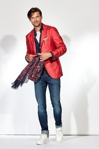 С чем носить разноцветный шелковый шарф мужчине в теплую погоду: Сочетание красного пиджака и разноцветного шелкового шарфа - очень практично, и поэтому великолепно подходит для создания беззаботного повседневного  образа. Закончив лук белыми низкими кедами из плотной ткани, можно привнести в него нотки мужественной элегантности.