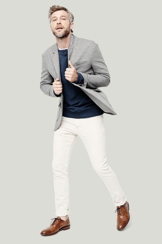 С чем носить свитер за 40 лет мужчине в стиле смарт-кэжуал: Сочетание свитера и белых джинсов позволит воплотить в твоем ансамбле городской стиль современного мужчины. Сделать образ изысканнее позволят коричневые кожаные оксфорды.