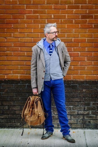 Как носить синие джинсы с темно-серым пиджаком за 40 лет мужчине в стиле смарт-кэжуал: Темно-серый пиджак в сочетании с синими джинсами — прекрасный пример непринужденного офисного стиля для молодых людей. Хочешь привнести в этот лук нотку классики? Тогда в качестве обуви к этому ансамблю, стоит обратить внимание на серые кожаные броги.