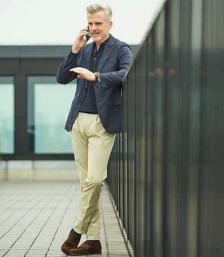 С чем носить бежевые классические брюки за 50 лет мужчине: Комбо из темно-синего пиджака и бежевых классических брюк — образец делового городского стиля. Что же до обуви, коричневые замшевые лоферы — наиболее целесообразный вариант.