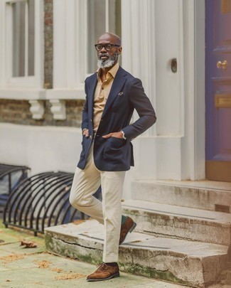 Какие броги носить с светло-коричневыми классическими брюками в стиле смарт-кэжуал: Темно-синий пиджак смотрится отлично в сочетании со светло-коричневыми классическими брюками. Любишь смелые сочетания? Закончи свой образ брогами.