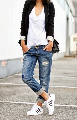 С чем носить синие рваные джинсы-бойфренды в спортивном стиле: Черный пиджак и синие рваные джинсы-бойфренды — прекрасная формула для воплощения стильного и практичного ансамбля. Создать модный контраст с остальными составляющими этого образа помогут белые кроссовки.