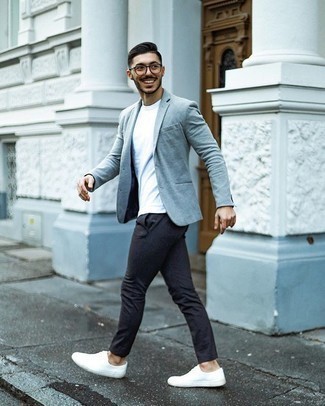 Как носить серый пиджак с темно-серыми брюками чинос в стиле кэжуал: Серый пиджак в сочетании с темно-серыми брюками чинос — прекрасный пример привлекательного офисного стиля для джентльменов. Создать красивый контраст с остальными предметами из этого образа помогут белые низкие кеды из плотной ткани.