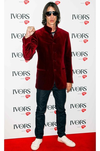 С чем носить темно-красный бархатный пиджак мужчине в стиле кэжуал: Темно-красный бархатный пиджак и темно-синие джинсы — идеальный вариант для повседневного офисного образа. Почему бы не привнести в этот образ чуточку легкости с помощью белых кожаных низких кед?