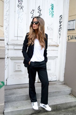 С чем носить черный пиджак женщине в стиле смарт-кэжуал: Черный пиджак и черные классические брюки помогут создать интересный лук для работы в офисе. Что касается обуви, можно отдать предпочтение комфорту и надеть белые кожаные низкие кеды.