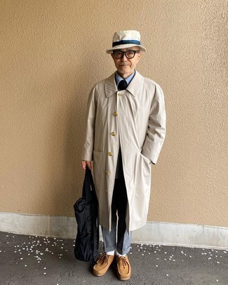 С чем носить темно-серые классические брюки за 60 лет мужчине: Сочетание бежевого плаща и темно-серых классических брюк позволит реализовать строгий деловой стиль. Такой ансамбль легко адаптировать к повседневным реалиям, если надеть в сочетании с ним светло-коричневые замшевые ботинки дезерты.