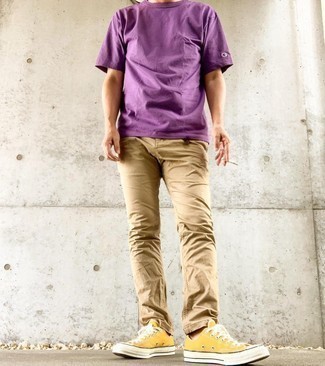 С чем носить золотые кеды мужчине: Пурпурная футболка с круглым вырезом и светло-коричневые брюки чинос позволят создать нескучный и модный лук. Чтобы лук не получился слишком вычурным, можно надеть золотые кеды.