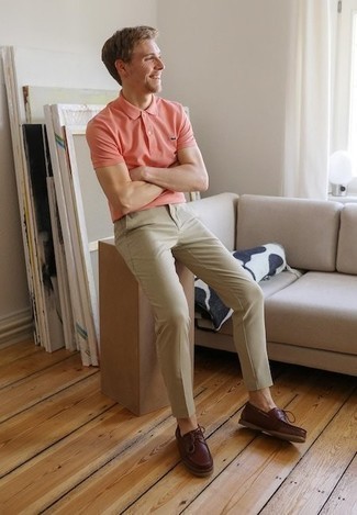 С чем носить розовую футболку-поло в 20 лет мужчине в стиле кэжуал: Комбо из розовой футболки-поло и светло-коричневых брюк чинос — превосходная идея для создания мужского лука в стиле элегантной повседневности. В качестве обуви сюда напрашиваются темно-красные кожаные топсайдеры.