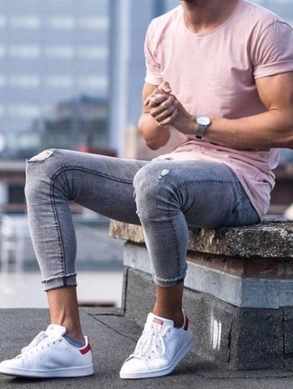 С чем носить темно-серые рваные зауженные джинсы мужчине в жару: Розовая футболка с круглым вырезом и темно-серые рваные зауженные джинсы — замечательная формула для создания приятного и незамысловатого образа. Любишь яркие сочетания? Закончи ансамбль белыми кожаными низкими кедами.