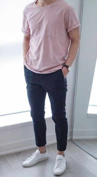 Модный лук: розовая футболка с круглым вырезом, темно-синие брюки чинос, белые кожаные низкие кеды, черные кожаные часы