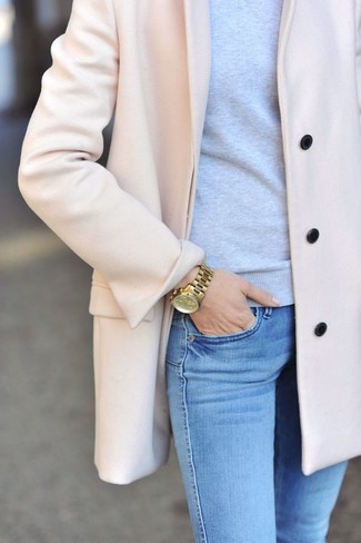 Модный лук: розовое пальто, серый свитер с круглым вырезом, голубые джинсы скинни, золотые часы