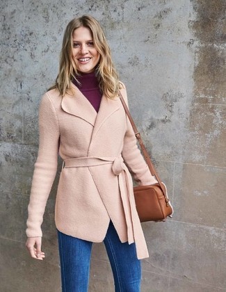 С чем носить розовое вязаное пальто женщине в холод: Лук из розового вязаного пальто и синих джинсов скинни — олицетворение современного городского стиля.