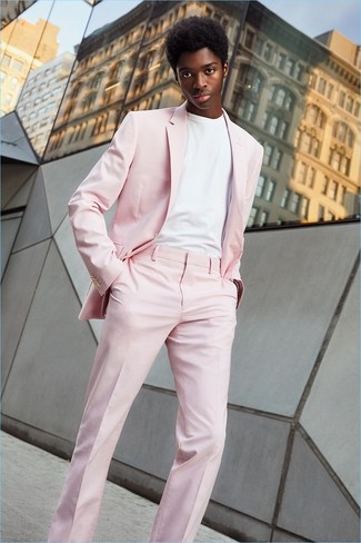 С чем носить розовый костюм в 20 лет лето в стиле смарт-кэжуал: Розовый костюм в сочетании с белой футболкой с круглым вырезом поможет подчеркнуть твой личный стиль. Такой лук подарит тебе комфорт и удобство в жаркую погоду.