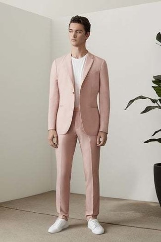 С чем носить розовый костюм в 20 лет: Розовый костюм и белая футболка с круглым вырезом помогут составить нескучный мужской лук для рабочего дня в офисе. Закончив лук белыми низкими кедами из плотной ткани, ты привнесешь в него немного беззаботства.