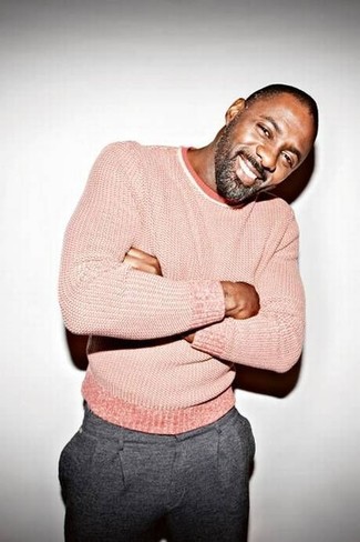 Как Idris Elba носит Розовый свитер с круглым вырезом, Серые шерстяные классические брюки