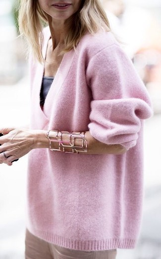 С чем носить ярко-розовый свободный свитер: Для вечера в кино или кафе великолепно подойдет образ из ярко-розового свободного свитера и светло-коричневых узких брюк.