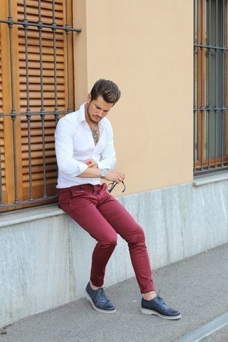 С чем носить темно-красные брюки чинос в стиле смарт-кэжуал: Белая рубашка с длинным рукавом и темно-красные брюки чинос — необходимые вещи в арсенале любителей непринужденного стиля. Любители модных экспериментов могут дополнить образ темно-синими кожаными брогами, тем самым добавив в него немного нарядности.