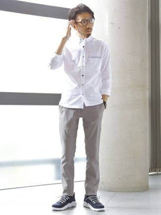 Модный лук: белая рубашка с длинным рукавом, серые брюки чинос, темно-сине-белые кроссовки, прозрачные солнцезащитные очки