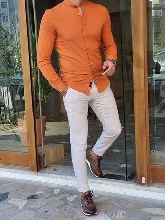Модный лук: оранжевая рубашка с длинным рукавом, белые брюки чинос, темно-коричневые кроссовки, светло-коричневые кожаные часы