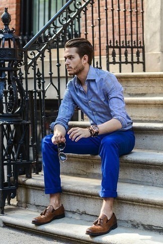 Как носить синие брюки чинос с коричневыми кожаными лоферами с кисточками в теплую погоду: Голубая рубашка с длинным рукавом в шотландскую клетку и синие брюки чинос — хороший выбор, если ты хочешь составить лёгкий, но в то же время модный мужской лук. Почему бы не привнести в этот лук на каждый день чуточку изысканности с помощью коричневых кожаных лоферов с кисточками?