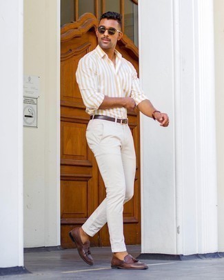 С чем носить желтую рубашку с длинным рукавом в вертикальную полоску мужчине лето: Если ты любишь одеваться модно, чувствуя себя при этом комфортно и нескованно, тебе стоит опробировать это сочетание желтой рубашки с длинным рукавом в вертикальную полоску и белых брюк чинос. Боишься выглядеть неаккуратно? Закончи этот лук темно-коричневыми кожаными лоферами с кисточками. Пережить мучительный летний зной в таком сочетании будет намного проще.
