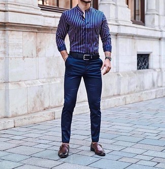 С чем носить синюю рубашку с длинным рукавом в вертикальную полоску мужчине: Если ты любишь выглядеть с иголочки, чувствуя себя при этом комфортно и уверенно, примерь на себя это сочетание синей рубашки с длинным рукавом в вертикальную полоску и темно-синих брюк чинос. Хотел бы сделать ансамбль немного элегантнее? Тогда в качестве дополнения к этому образу, выбери темно-красные кожаные монки.