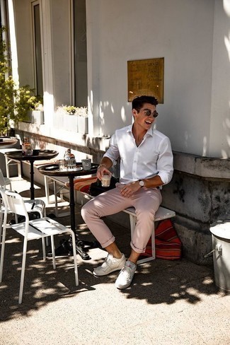 С чем носить розовые брюки чинос: Если ты ценишь комфорт и практичность, попробуй сочетание белой рубашки с длинным рукавом и розовых брюк чинос. Дерзкие молодые люди дополнят образ белыми кожаными низкими кедами.