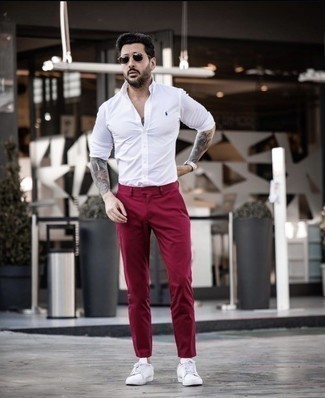 Какие рубашки с длинным рукавом носить с темно-красными брюками чинос в стиле кэжуал: Рубашка с длинным рукавом в сочетании с темно-красными брюками чинос — хорошая идея для создания мужского ансамбля в элегантно-деловом стиле. Ты сможешь легко адаптировать такой образ к повседневным делам, дополнив его белыми низкими кедами из плотной ткани.