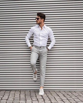 С чем носить белые кожаные низкие кеды мужчине: Сочетание белой рубашки с длинным рукавом и серых брюк чинос смотрится привлекательно и по моде. Белые кожаные низкие кеды помогут сделать образ менее официальным.