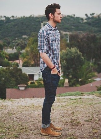 С чем носить темно-сине-белую рубашку с длинным рукавом в шотландскую клетку мужчине: Сочетание темно-сине-белой рубашки с длинным рукавом в шотландскую клетку и темно-синих джинсов — прекрасная идея для воплощения мужского лука в стиле smart casual. И почему бы не добавить в повседневный образ немного нарядности с помощью светло-коричневых замшевых ботинок дезертов?