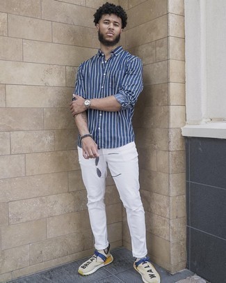 Какие джинсы носить с бежевыми кроссовками мужчине в спортивном стиле: Темно-сине-белая рубашка с длинным рукавом в вертикальную полоску и джинсы — замечательная формула для создания привлекательного и простого образа. Любишь незаурядные решения? Можешь завершить свой образ бежевыми кроссовками.