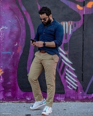 С чем носить бежевые джинсы мужчине в теплую погоду в спортивном стиле: Если этот день тебе предстоит провести в движении, сочетание темно-синей рубашки с длинным рукавом из шамбре и бежевых джинсов поможет составить функциональный образ в стиле casual. Белые кроссовки помогут сделать лук менее формальным.