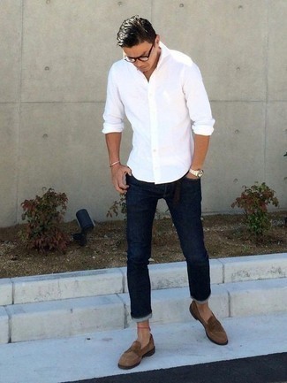 Как носить темно-синие джинсы с коричневыми замшевыми лоферами за 40 лет мужчине в стиле смарт-кэжуал: В паре друг с другом белая рубашка с длинным рукавом и темно-синие джинсы смотрятся очень выигрышно. Почему бы не добавить в этот образ на каждый день немного консерватизма с помощью коричневых замшевых лоферов?