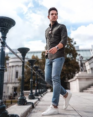 С чем носить темно-серую рубашку с длинным рукавом мужчине в стиле кэжуал: Если ты любишь выглядеть по моде, и при этом чувствовать себя комфортно и уверенно, попробуй это сочетание темно-серой рубашки с длинным рукавом и голубых джинсов. Белые низкие кеды из плотной ткани — великолепный вариант, чтобы дополнить образ.