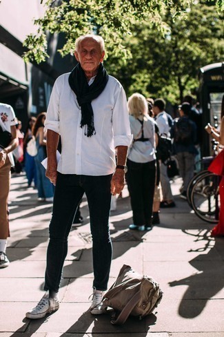 С чем носить темно-синие зауженные джинсы за 60 лет мужчине весна в стиле кэжуал: Если превыше всего ты ценишь удобство и практичность, не обходи стороной тандем белой рубашки с длинным рукавом и темно-синих зауженных джинсов. Если тебе нравится экспериментировать, на ноги можешь надеть белые высокие кеды из плотной ткани. Такое сочетание одежды обязательно будет у тебя одним из самых любимых в весенне-осенний период.