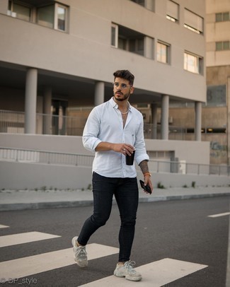 С чем носить черные зауженные джинсы мужчине: Комбо из белой рубашки с длинным рукавом и черных зауженных джинсов позволит выразить твой личный стиль и выделиться из общей массы. Бежевые кроссовки создадут легкое настроение.