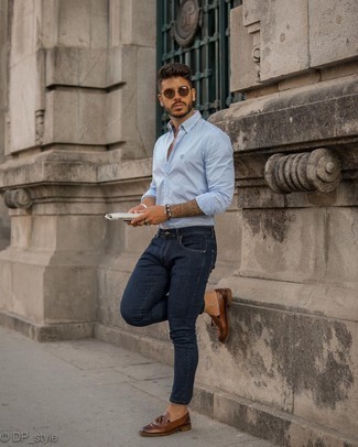 С чем носить темно-синие зауженные джинсы мужчине лето: Если ты делаешь ставку на удобство и практичность, голубая рубашка с длинным рукавом в вертикальную полоску и темно-синие зауженные джинсы — великолепный выбор для модного мужского образа на каждый день. Уравновесить лук и добавить в него чуточку классики позволят темно-коричневые кожаные лоферы с кисточками. Нам очень нравится такой образ на лето.