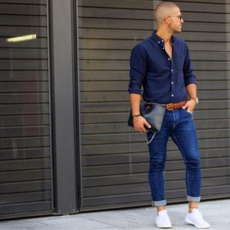 Какие зауженные джинсы носить с темно-синей рубашкой с длинным рукавом мужчине в теплую погоду в стиле кэжуал: Комбо из темно-синей рубашки с длинным рукавом и зауженных джинсов — превосходная идея для воплощения мужского ансамбля в стиле business casual. В сочетании с этим образом органично будут смотреться белые низкие кеды.