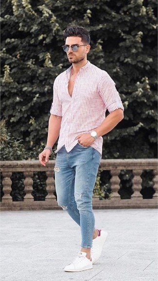 С чем носить розовую рубашку с длинным рукавом в 20 лет мужчине в теплую погоду в спортивном стиле: Если в одежде ты ценишь комфорт и функциональность, розовая рубашка с длинным рукавом и голубые рваные зауженные джинсы — отличный вариант для привлекательного повседневного мужского ансамбля. Думаешь привнести в этот наряд толику элегантности? Тогда в качестве дополнения к этому ансамблю, стоит обратить внимание на белые кожаные низкие кеды.