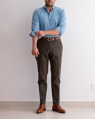 С чем носить темно-коричневые классические брюки в 30 лет мужчине в теплую погоду: Голубая рубашка с длинным рукавом из шамбре в сочетании с темно-коричневыми классическими брюками позволит примерить на себя изысканный мужской стиль. Очень органично здесь будут смотреться табачные кожаные броги.