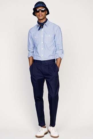 Модный лук: голубая рубашка с длинным рукавом из жатого хлопка, темно-синие классические брюки, белые кожаные туфли дерби, темно-синяя шляпа