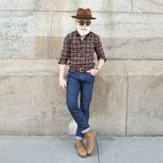 Какие повседневные ботинки носить с темно-синими джинсами за 60 лет мужчине в теплую погоду: Если ты любишь одеваться с иголочки, чувствуя себя при этом комфортно и расслабленно, опробируй это сочетание коричневой рубашки с длинным рукавом в шотландскую клетку и темно-синих джинсов. Хотел бы добавить в этот наряд нотку классики? Тогда в качестве обуви к этому луку, стоит обратить внимание на повседневные ботинки.