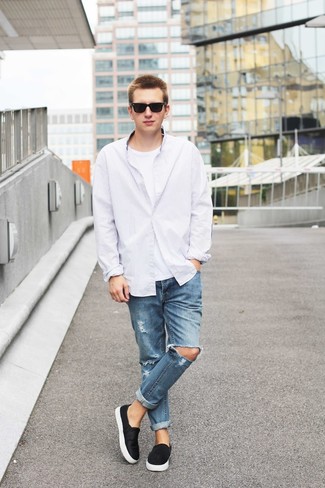 Модный лук: белая рубашка с длинным рукавом в вертикальную полоску, белая футболка с круглым вырезом, синие рваные джинсы, черные замшевые слипоны